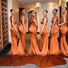 the beautiful women in orange dresses are posing for a photo together, all dressed up and ready