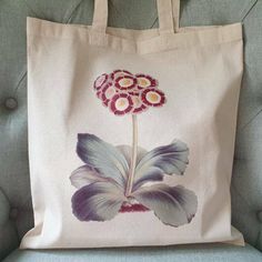 This lovely auricula flower print cotton tote is the perfect gift for gardeners in your life! Made of high-quality, reusable cotton, this bag is not only stylish but also eco-friendly. With its beautiful design featuring delicate auricula flowers, this tote is a great book bag or perfect for carrying either your essentials while showcasing your love for gardening. Add a touch of botanical beauty to your daily routine with this lovely tote! The shopper measures 38 x 42cm, and each one is made and Botanical Style Rectangular Cotton Canvas Bag, Botanical Cotton Canvas Tote Bag, Botanical Cotton Canvas Bag For Everyday Use, Botanical Cotton Canvas Bag For Daily Use, Botanical Cotton Tote Bag, Botanical Cotton Canvas Gift Bag, Botanical Style Cotton Tote Bag, Eco-friendly Cotton Canvas Bag With Floral Print, Botanical Cotton Bags As Gift