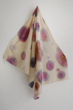 a pink and purple flowered scarf hanging on a white wall