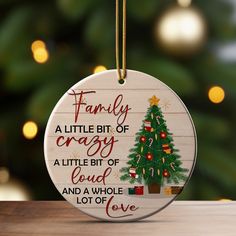 a christmas ornament hanging on a table with a tree and presents in the background