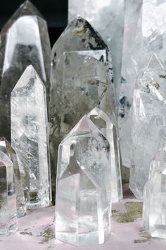 several clear crystal pieces sitting on top of a pink tablecloth covered table next to each other