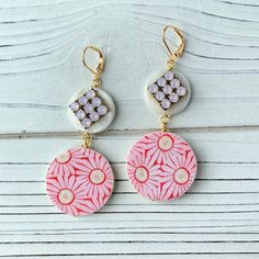 Vintage textile print in feminine pink daisy decoupaged on a disc, with the second disc in mother of pearl adorned with sparkling high-quality Swarovski bling in pink opal. Earrings have a lever back nickel free closure and a 3-inch drop. Perfect summer earrings to complete that beach outfit! Thanks for looking! Vintage Pink Earrings For Summer, Pink Round Earrings For Summer, Pink Round Summer Earrings, Pink Opal Earrings, Textile Print, Vintage Textile, Summer Earrings, Summer Earring, Pink Daisy