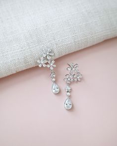 Delicate pear shape dangle earring seamlessly blend with floral rhinestones and accented with small pearls adds a classic touch for your ensemble. Pair them with an elegant dress for formal affair, or let them elevate your casual style. Perfect for date night, wedding, bridesmaids, holiday party, and any special occasions. DETAILS: LENGTH: 1.75"COLOR: SILVERIMPORTED MATERIALS Elegant Crystal Flower Earrings For Party, Elegant Flower Earrings With Sparkling Stones For Wedding, Elegant Wedding Flower Earrings With Sparkling Stones, Elegant Crystal Drop Bridal Earrings, Elegant Flower Drop Earrings For Evening, Elegant Evening Flower Drop Earrings, Elegant Pear-shaped Chandelier Earrings For Formal Occasions, Formal Dangle Flower Earrings With Cubic Zirconia, Elegant Crystal Teardrop Earrings For Formal Occasions