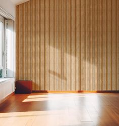 an empty room with wood flooring and vertical blinds on the window sill,