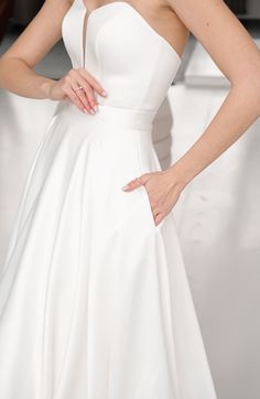 a woman in a white dress with her hands on her hip and the back of her head