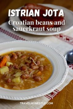 a bowl of stew with beans and potatoes in it on a table next to a spoon