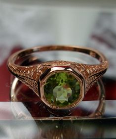 Natural Green Peridot Ring Dandelion Design#205 Custom This is a stunning Edwardian wedding reproduction gemstone filigree ring. The .85ct natural green peridot gemstone is 6mm in diameter. This lovely ring is 10K Rose Gold is marked 10K on the inner shank. Notice the beautiful craftsmanship of the rose gold filigree setting. This is an ornate and detailed ring. This is a lovely rendition of an Antique filigree wedding ring, and it is ready to wear. A ring gift box is included and all rings are Vintage Green Solitaire Ring, Vintage Green Solitaire Jewelry, 14k Gold Green Rings With Intricate Design, Green 14k Gold Rings With Intricate Design, Victorian Green Engraved Ring, Vintage Peridot Ring For May Birthstone, Antique May Birthstone Rings For Wedding, Antique May Birthstone Wedding Rings, Green Engraved Wedding Rings