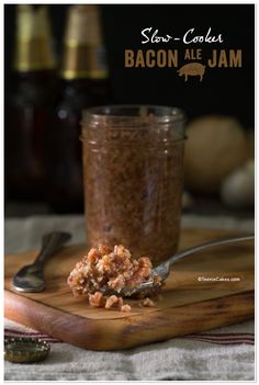 bacon ale jam in a glass jar with spoon on wooden cutting board next to it