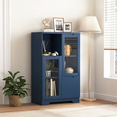 a blue bookcase in the corner of a room with a lamp and pictures on it