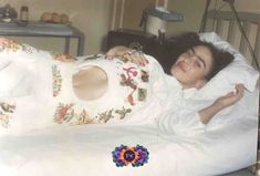 an old photo of a woman laying in bed