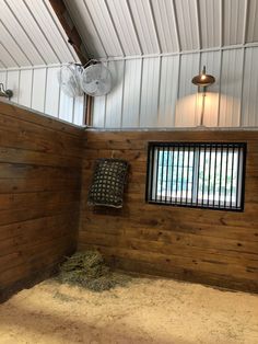 the inside of a barn with hay on the floor