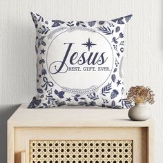 a pillow that says jesus best gift ever on it next to a vase with flowers