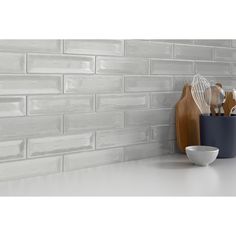 a kitchen counter with some utensils on it and a white brick wall in the background