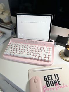 a pink laptop computer sitting on top of a desk next to a keyboard and mouse