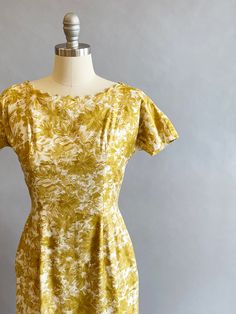 "1950s cotton sateen very fitted day dress. Ivory ground with an all over mustard brush stroke floral print. The neckline is pointed scallops. Top-stitched seams across the bodice, as well as form fitting vertical seams front and back. Cap sleeves, a V-back, with a metal zipper and hook and eye closure. Size- Small Bust - 34\" Waist - 27\" Hips - 39\" Length - 39\" Label: Janice Jr. Condition: Excellent vintage condition. All vintage is sold in \"as-is\" condition. We do our best to inspect, cor Yellow Fitted Dress In 1950s Style, Fitted Yellow Dress In 1950s Style, Mustard Fitted Cotton Dress, Fitted Mustard Cotton Dress, Mustard Fitted Floral Print Dress, Fitted Mustard Floral Print Dress, Fitted Yellow 1950s Dresses, Fitted Vintage Mustard Dress, Fitted Mid-century Yellow Dress