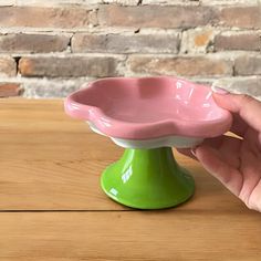 a person is holding a pink flower shaped bowl