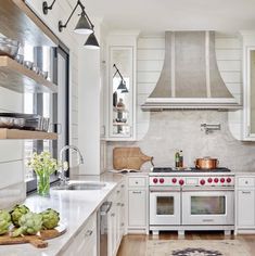 a kitchen with white cabinets and an oven in the center is featured on instagram