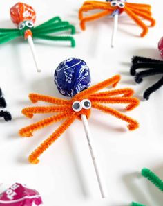 an assortment of lollipops with googly eyes and spider legs on them