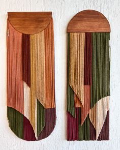 two wall hangings made out of wood with different colored fringes and shapes on them