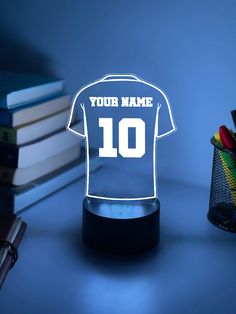 a light up soccer jersey with the name and number on it, sitting next to a stack of books