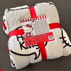 three hello kitty towels wrapped in red and white ribbon with the word hello kitty on it