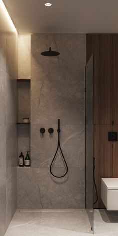 a bathroom with a walk in shower next to a white toilet and wooden shelves on the wall