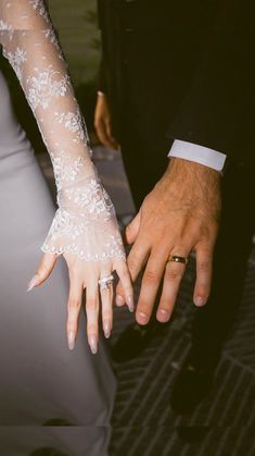 the bride and groom are holding each other's hands