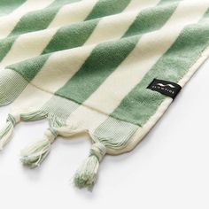 a green and white striped towel laying on top of a table