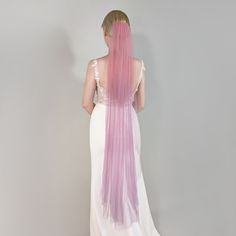 the back of a woman's dress with long pink and white hair on her head