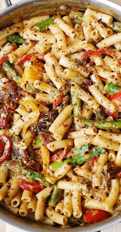 a pan filled with pasta and vegetables on top of a table