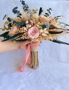 a person holding a bouquet of flowers on a white surface