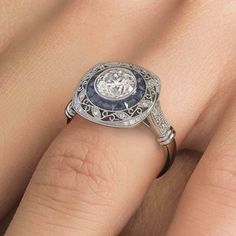 a woman's engagement ring with an old - fashioned diamond and blue sapphire in the center