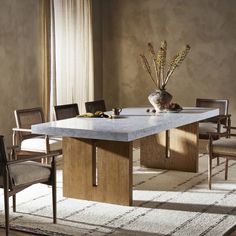 a dining room table with chairs and a vase filled with flowers on top of it