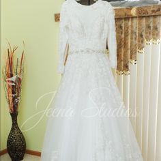 a white wedding dress on display in front of a window