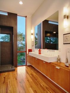 a bathroom with wooden floors and large windows