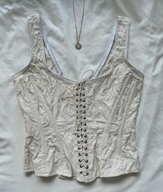 "Rare Vintage Gigi Clark ivory floral corset top, lace up. Cotton. Hook and eye closure. size S, pit to pit 34\", waist 26\", length 20.5\". very good vintage condition, slight discoloration due to age. not very noticeable" Sleeveless Beige Corset With Corset Back, Beige Sleeveless Corset With Corset Back, White Boned Bodice Corset For Spring, Beige Boned Bodice Sleeveless Corset, Beige Lace Fitted Corset, Cream Lace Corset With Boned Bodice, Spring Underbust Corset With Boned Bodice, Beige Sleeveless Corset With Boned Bodice, White Overbust Corset For Spring