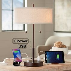 a table with an electronic device and charger on it next to a lamp that is plugged in