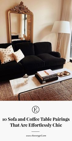 a living room with a black couch and coffee table in front of a large mirror