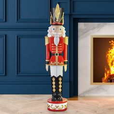 a nutcracker statue sitting in front of a fire place with a blue wall behind it