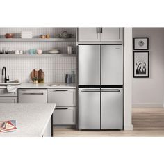 a silver refrigerator freezer sitting inside of a kitchen