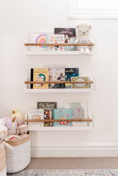 three shelves with books and stuffed animals on them in a child's playroom