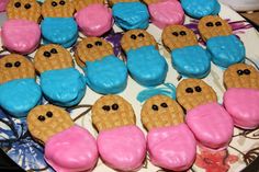 there are many cookies with pink and blue frosting in the shape of an owl