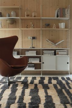 a living room filled with furniture and bookshelves next to a wall mounted clock