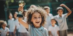 a young child holding up a trophy in front of other children