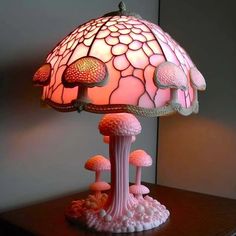 a pink lamp sitting on top of a wooden table