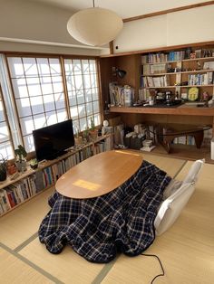 an empty room with a table and bookshelves in the corner, covered by a blanket