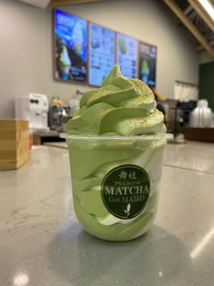 a cup of green tea ice cream on a counter in a restaurant or coffee shop