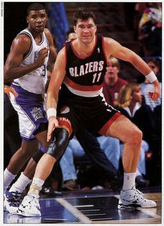 two men playing basketball in front of an audience