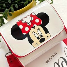 Add Some Magic To Your Style With This Charming Disney Mickey & Minnie Mouse Mini Crossbody Bag! Perfect For Disney Enthusiasts Of All Ages, This Waterproof Purse Boasts An Iconic Mickey Mouse Face On A Crisp White Backdrop, Complemented By A Vibrant Red Adjustable Strap For Comfort And Convenience. Whether You’re Running Errands Or Heading To The Parks, This Delightful Bag Is Sure To Turn Heads And Keep Your Essentials Safe In Any Weather. Disney Minnie Mouse White Bag, Disney Mickey Mouse Bags For Gifts, Trendy Minnie Mouse School Bag, Cute Mickey Mouse Bags For Disney Trips, Cute Mickey Mouse Bags For Gifts, Cute Mickey Mouse Bags As Gift, Cute Red Bag For Disney Trips, Red Minnie Mouse Bag For Gift, Disney White Bags For Disney Trips