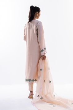 This timeless long shirt silhouette is cut from khaddi silk and is rendered with our signature floral embroidery. An organza dupatta with worked borders and rawsilk trousers complement the look. Elegant Salwar Kameez With Floral Embroidery In Raw Silk, Elegant Raw Silk Salwar Kameez With Floral Embroidery, Designer Naqshi Salwar Kameez In Tissue Silk, Elegant Naqshi Tissue Silk Kurta, Festive Organza Kurta With Naqshi Detailing, Silk Lawn Suit With Dabka Work, Designer Naqshi Lawn Suit In Organza, Semi-stitched Naqshi Tissue Silk Salwar Kameez, Designer Silk Lawn Suit With Naqshi Detailing